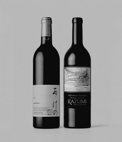 Two wine bottles, one labeled 'Akeno' and the other 'Kazumi', on a light gray background.
